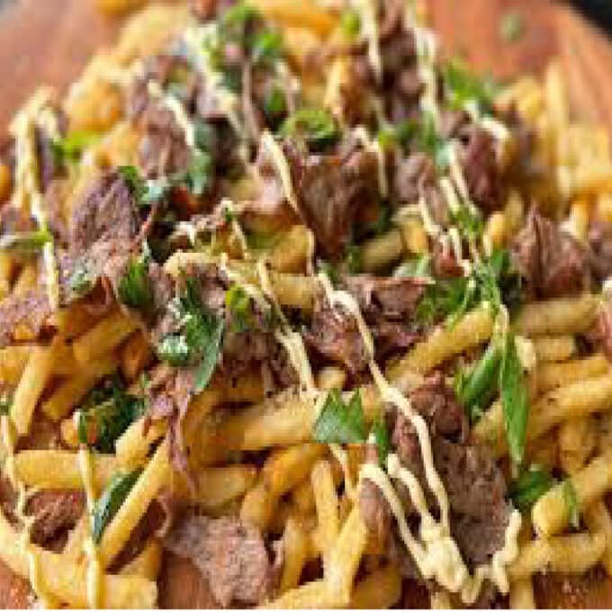 A hot, steaming bowl of golden fries stir-fried in a rich, savory dark sauce with colorful diced bell peppers and onions, served fresh at Let's Fry Away.